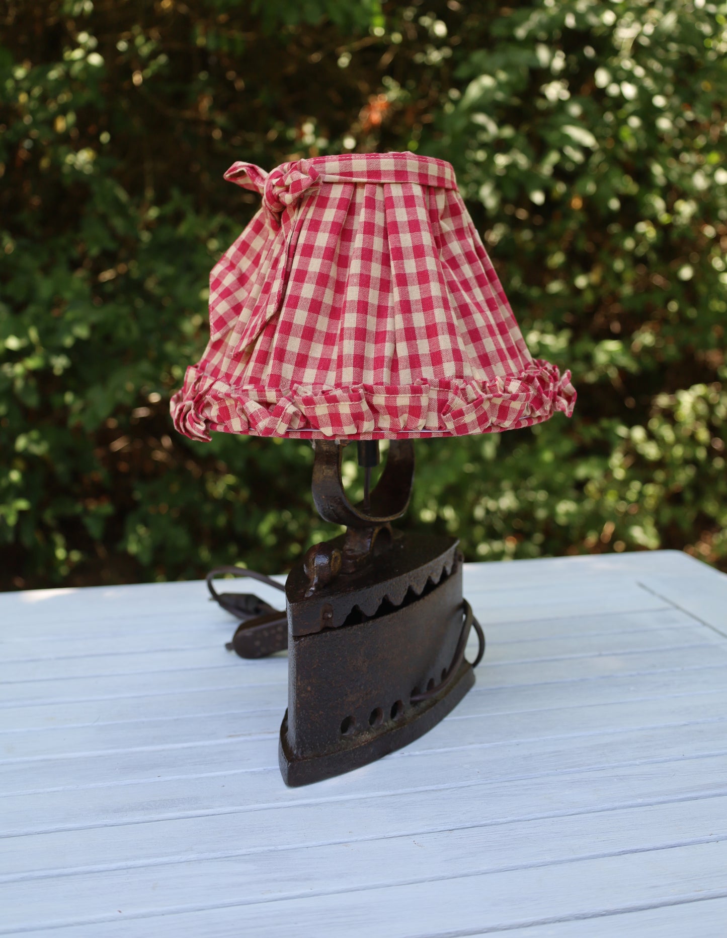 Tischleuchte aus altem Bügeleisen mit rotkariertem Lampenschirm