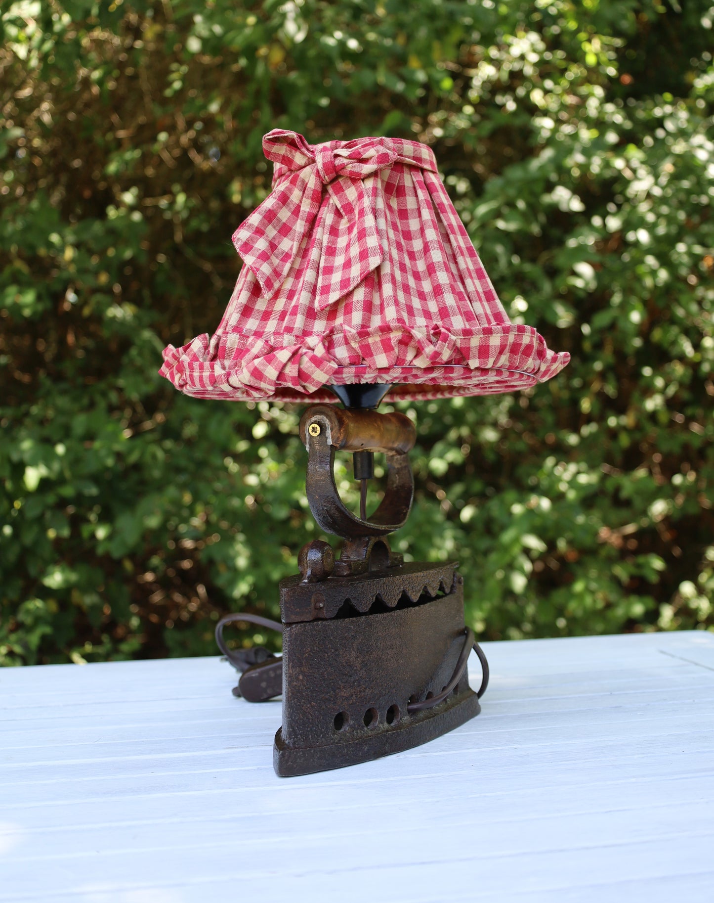 Tischleuchte aus altem Bügeleisen mit rotkariertem Lampenschirm